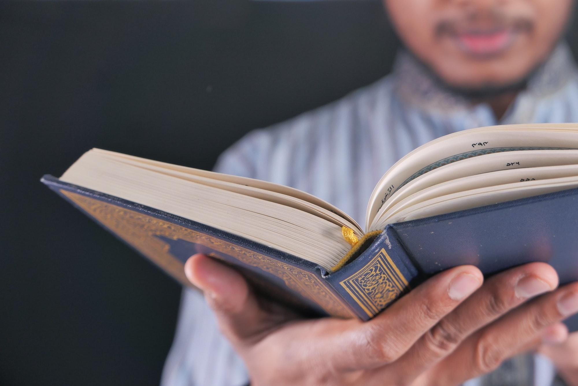 Muslim mans reading quran at night
